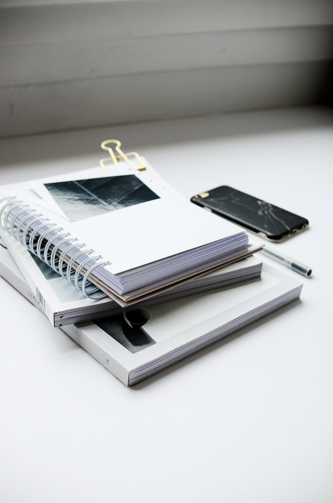 Bright office desk with telephone, notebook and pen