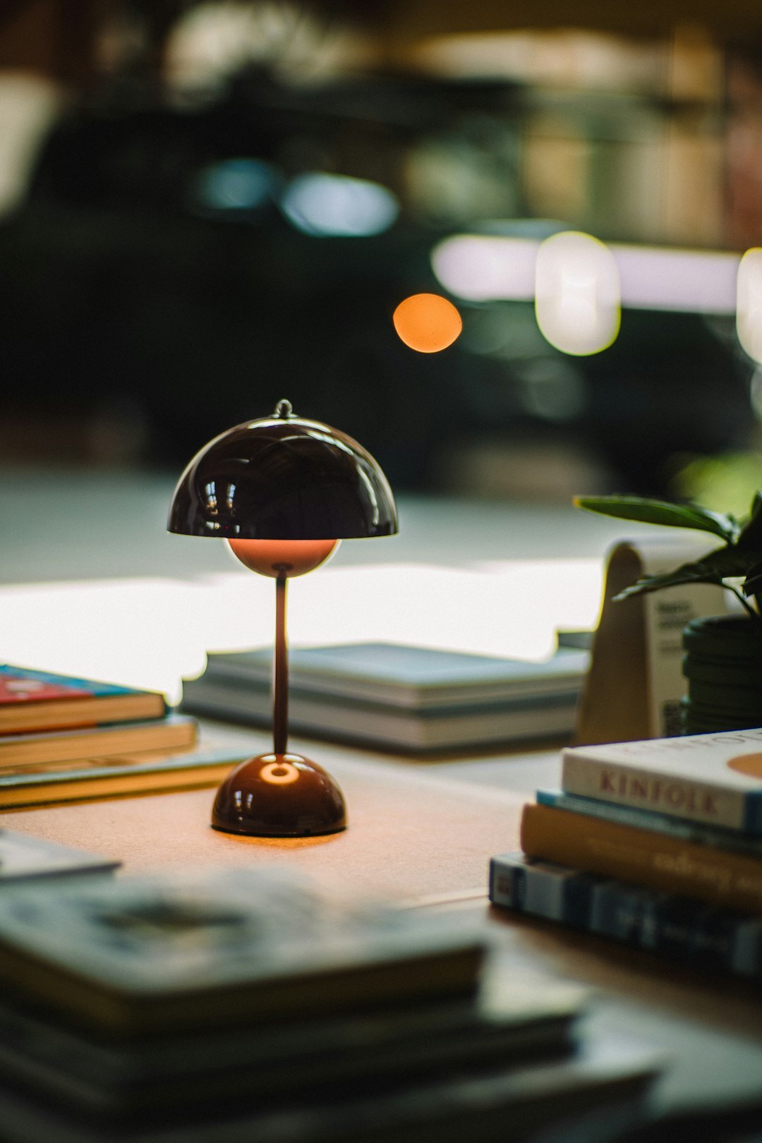 Stack of vintage lifestyle magazines and photographs on a wooden desk